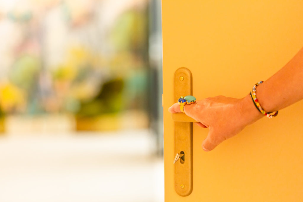 Main qui ouvre une porte de salle de réunion, Espaces Réunion