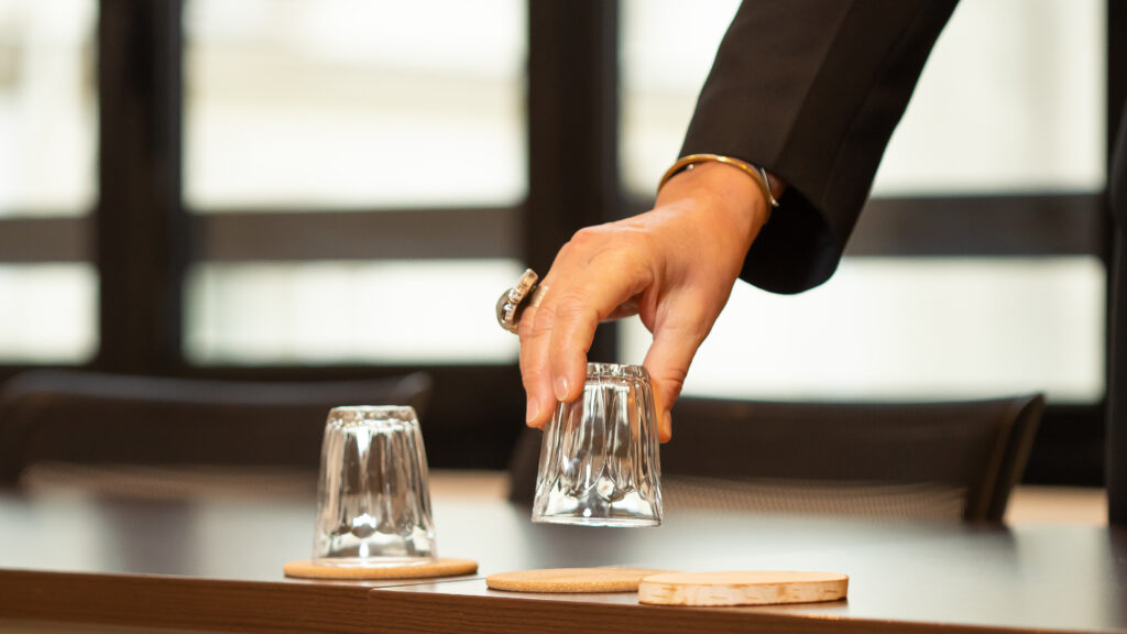Main qui pose un verre sur une table à Espaces Réunion